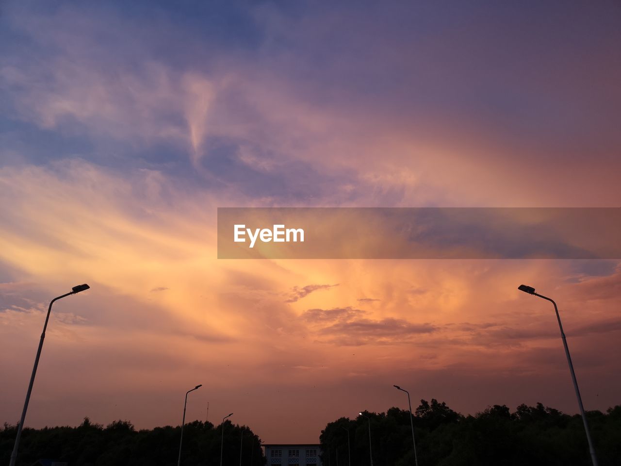 LOW ANGLE VIEW OF SILHOUETTE STREET LIGHTS AGAINST SKY DURING SUNSET