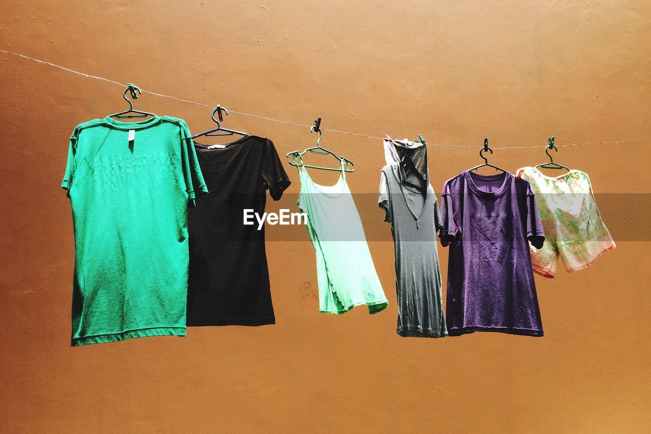 Low angle view of clothes drying on clothesline against wall