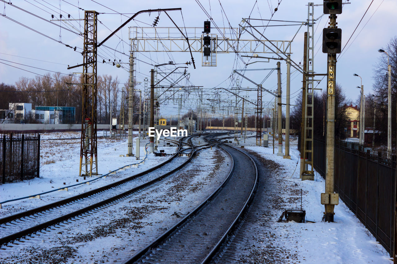 VIEW OF RAILWAY TRACKS AGAINST SNOW COVERED RAILROAD TRACK