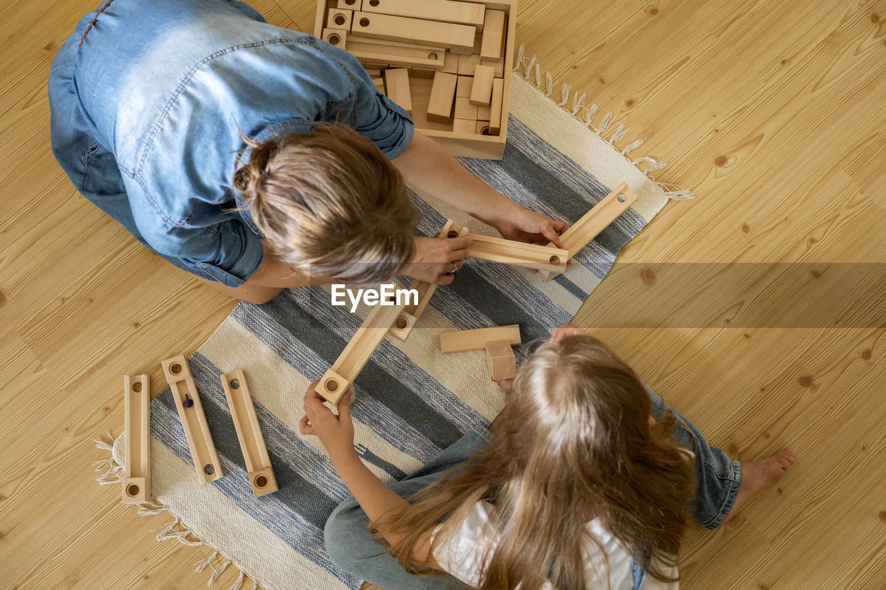 HIGH ANGLE VIEW OF MAN LYING DOWN ON HARDWOOD FLOOR