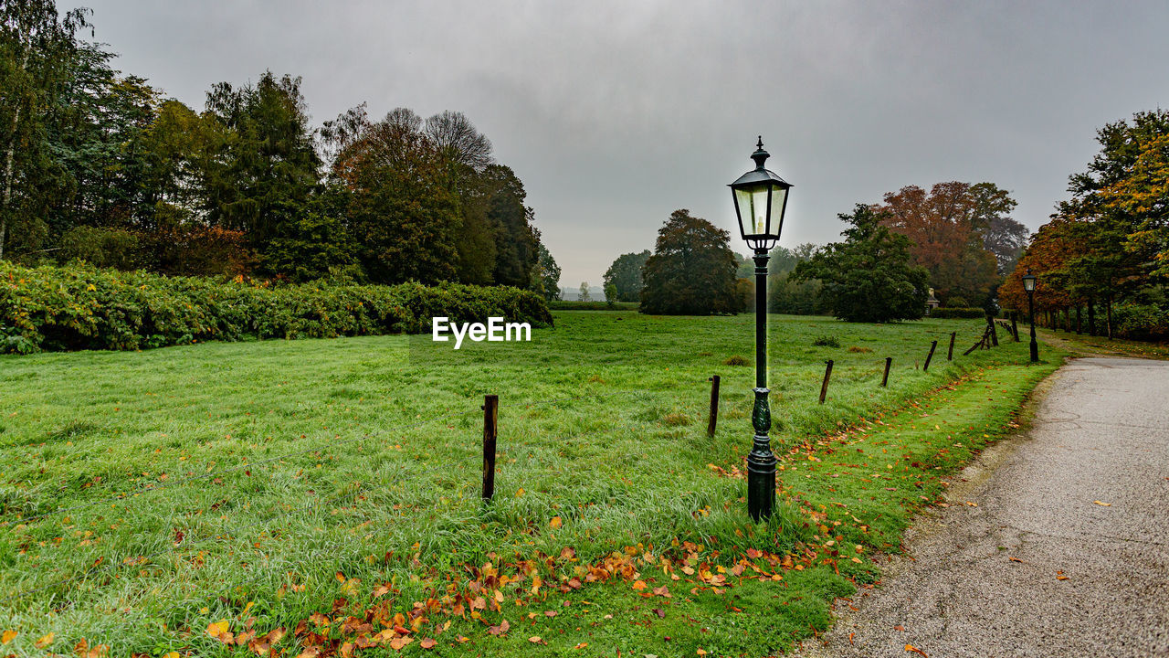 STREET LIGHTS ON FIELD BY PARK AGAINST SKY