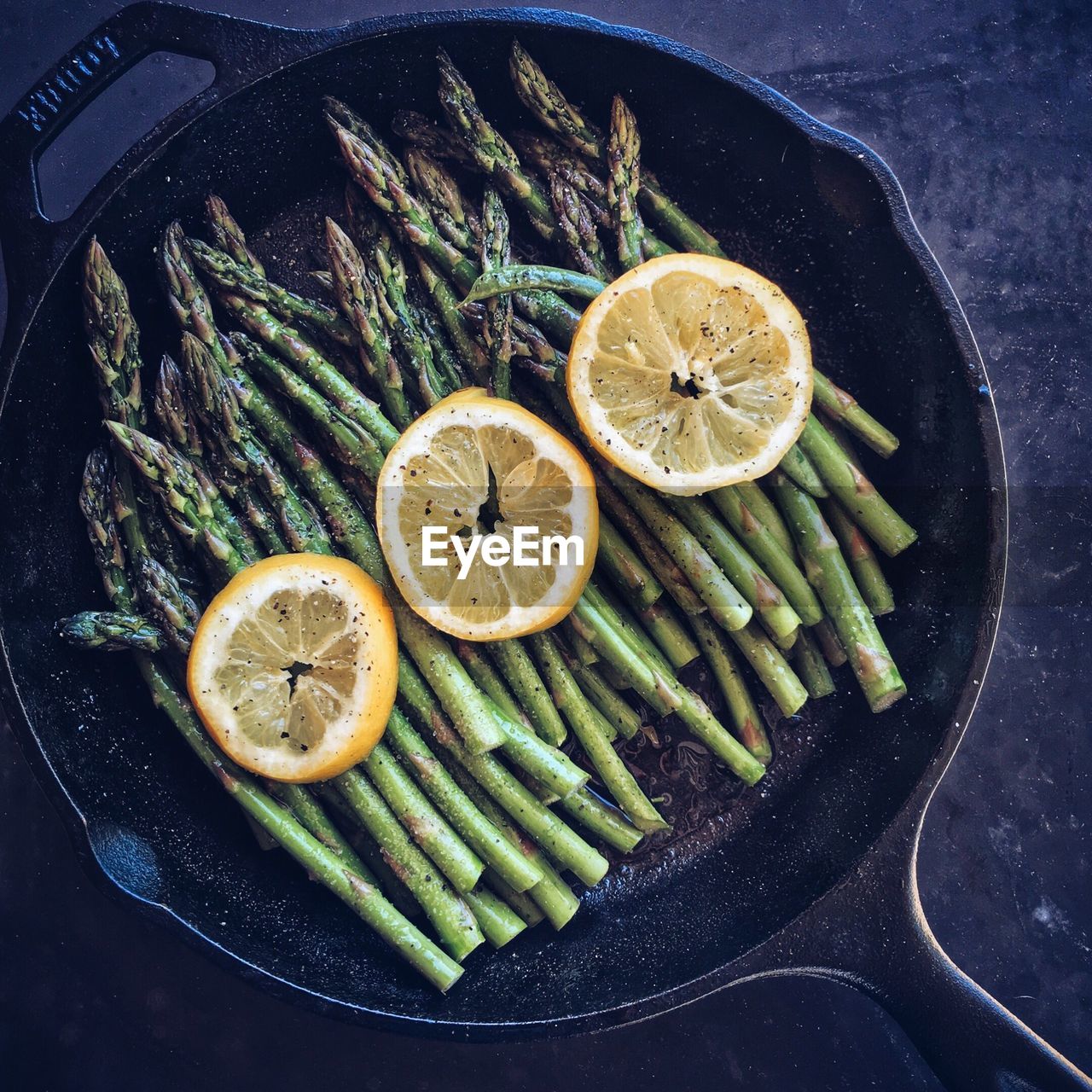 High angle view of asparagus with lemon slice in bowl