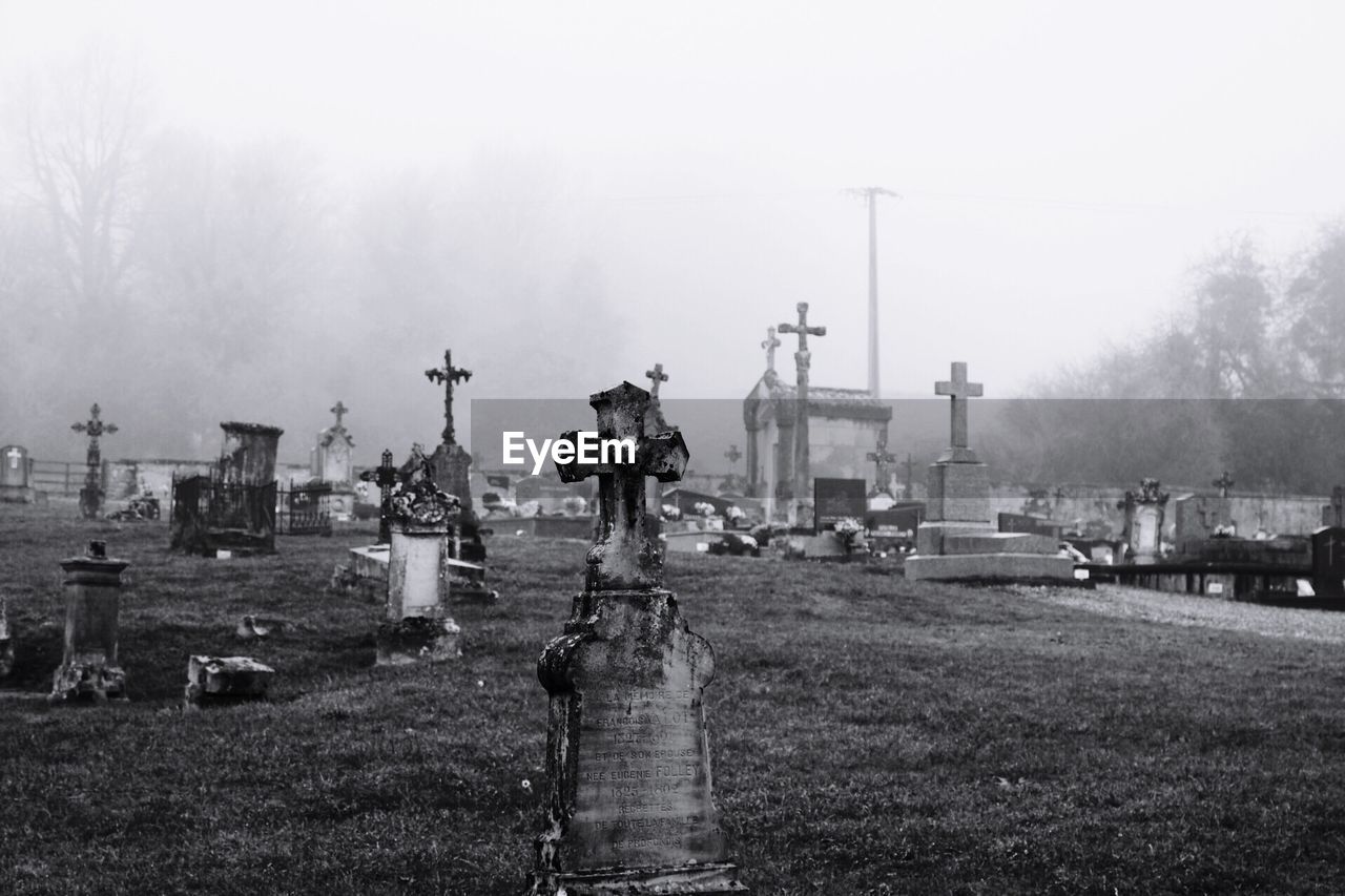 Crosses at cemetery during foggy weather