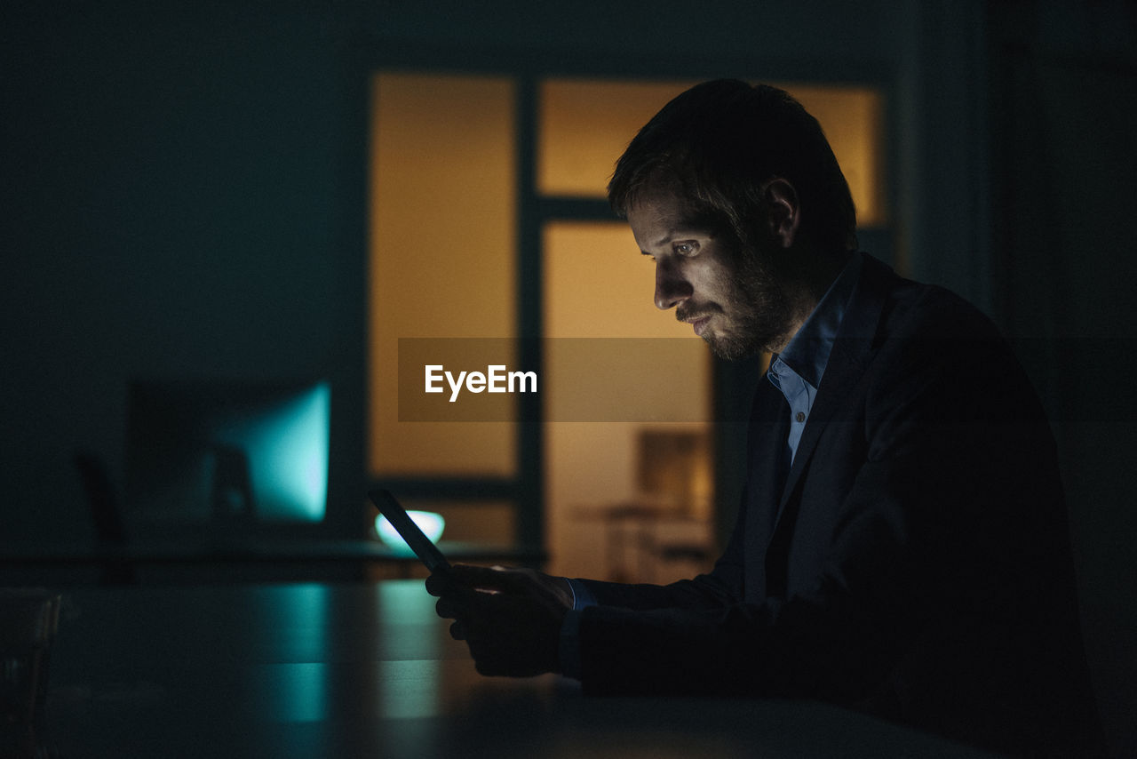 Businessman working late in office using tablet