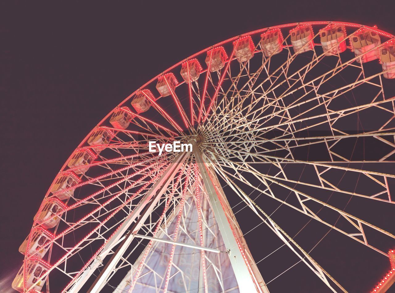 LOW ANGLE VIEW OF ILLUMINATED FERRIS WHEEL AGAINST CLEAR SKY