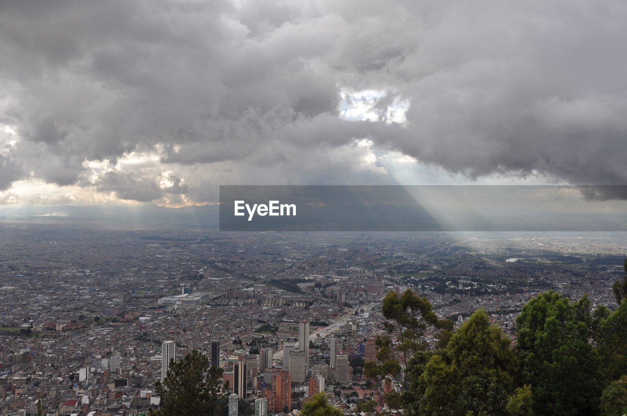 Aerial view of cityscape against storm clouds