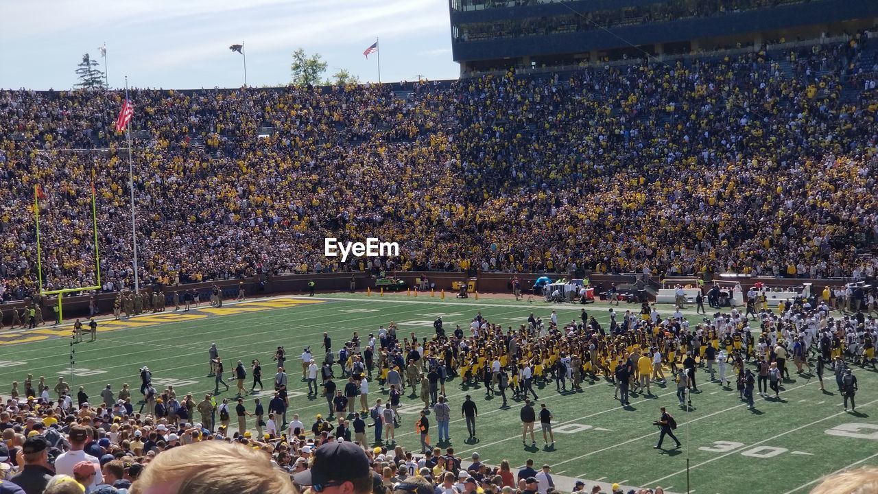 HIGH ANGLE VIEW OF GROUP OF PEOPLE LOOKING AT STADIUM