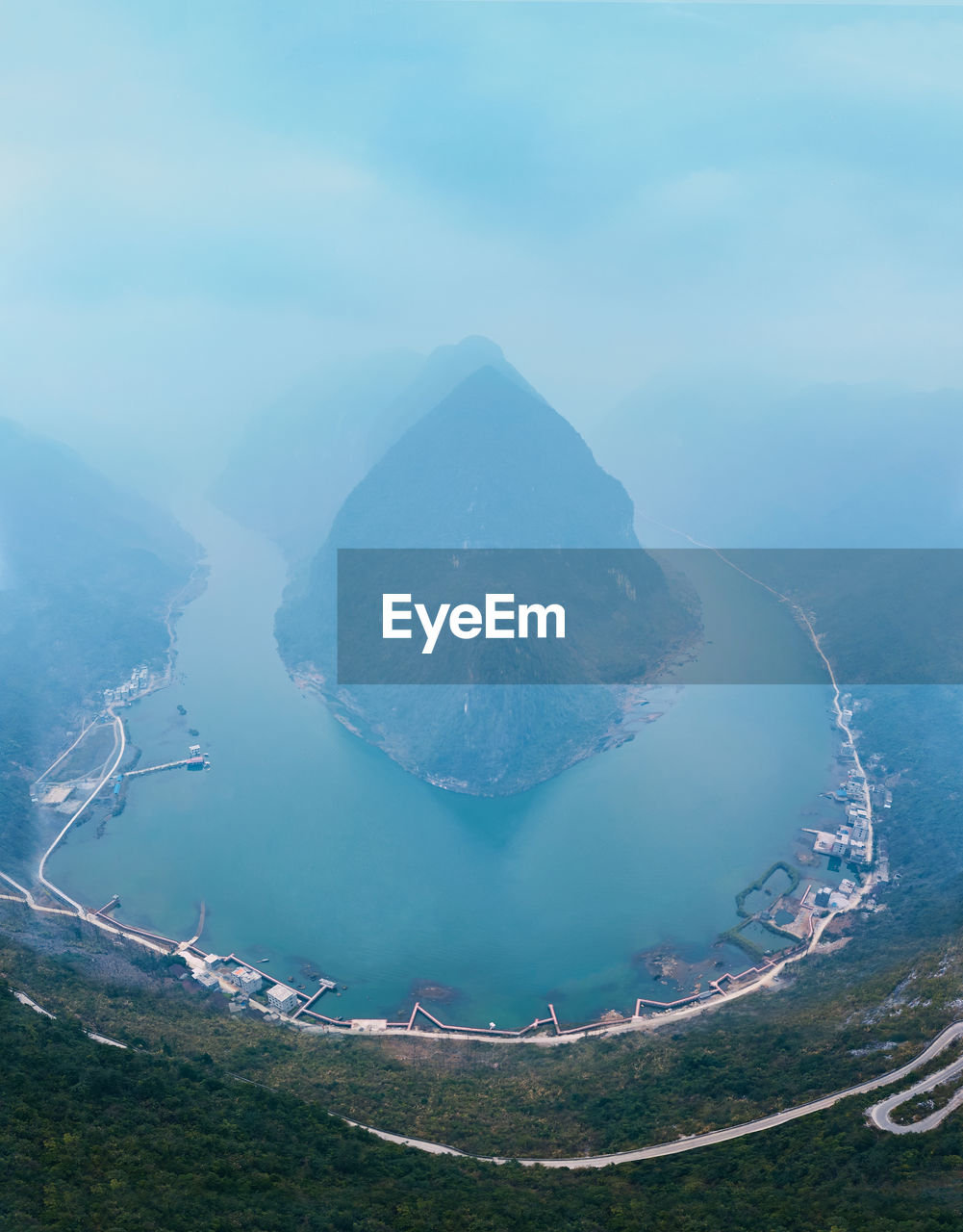 High angle view of sea by mountains against sky