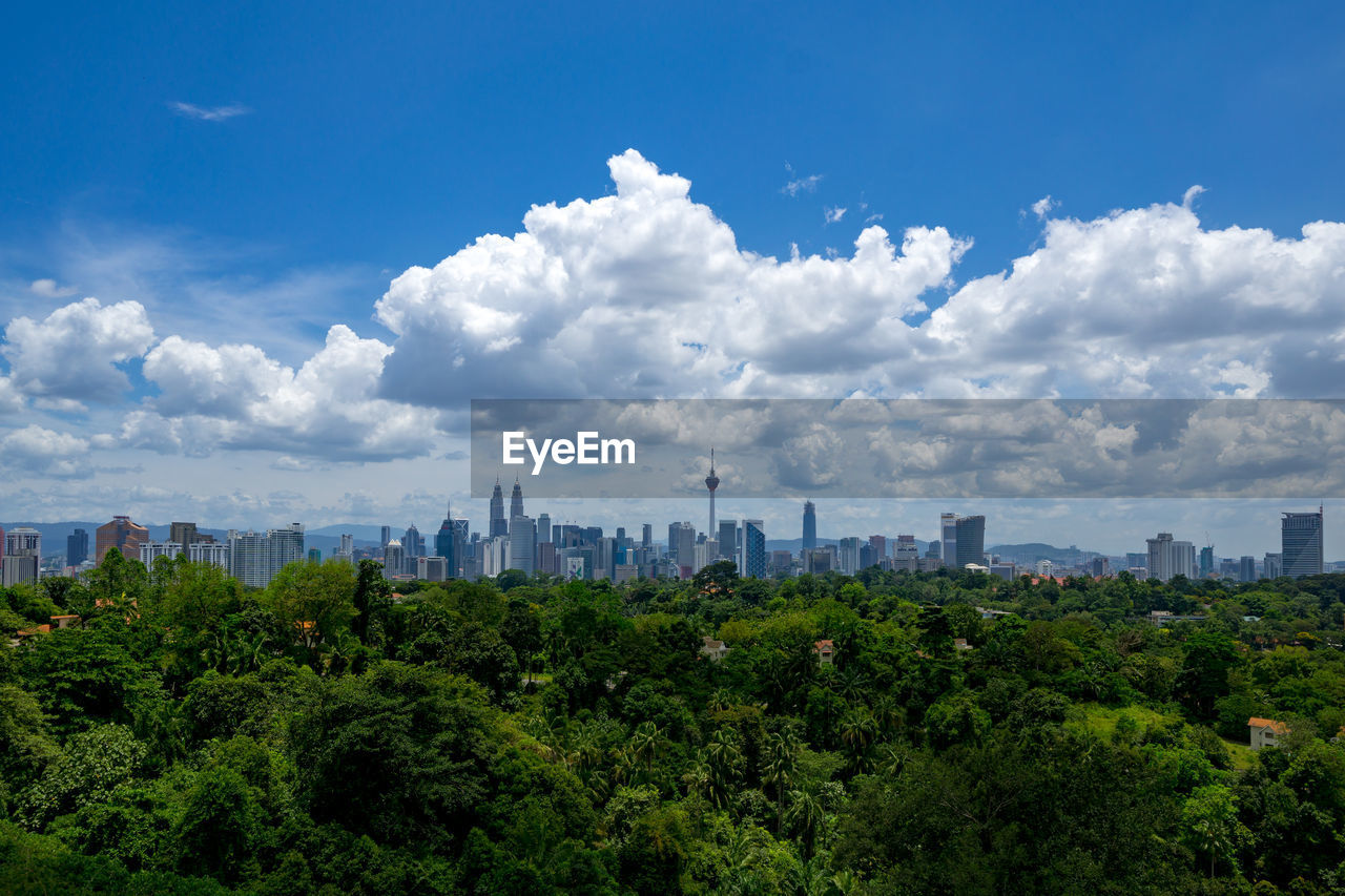 View of cityscape against cloudy sky