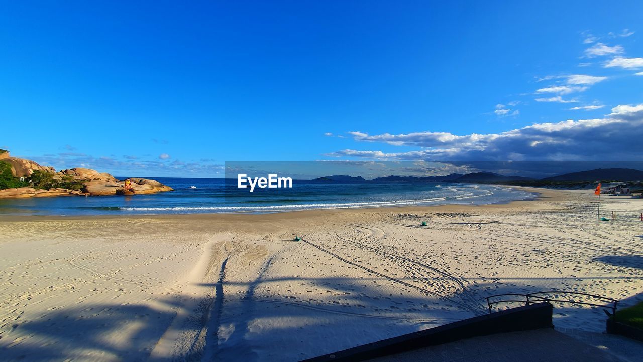 Scenic view of beach against blue sky