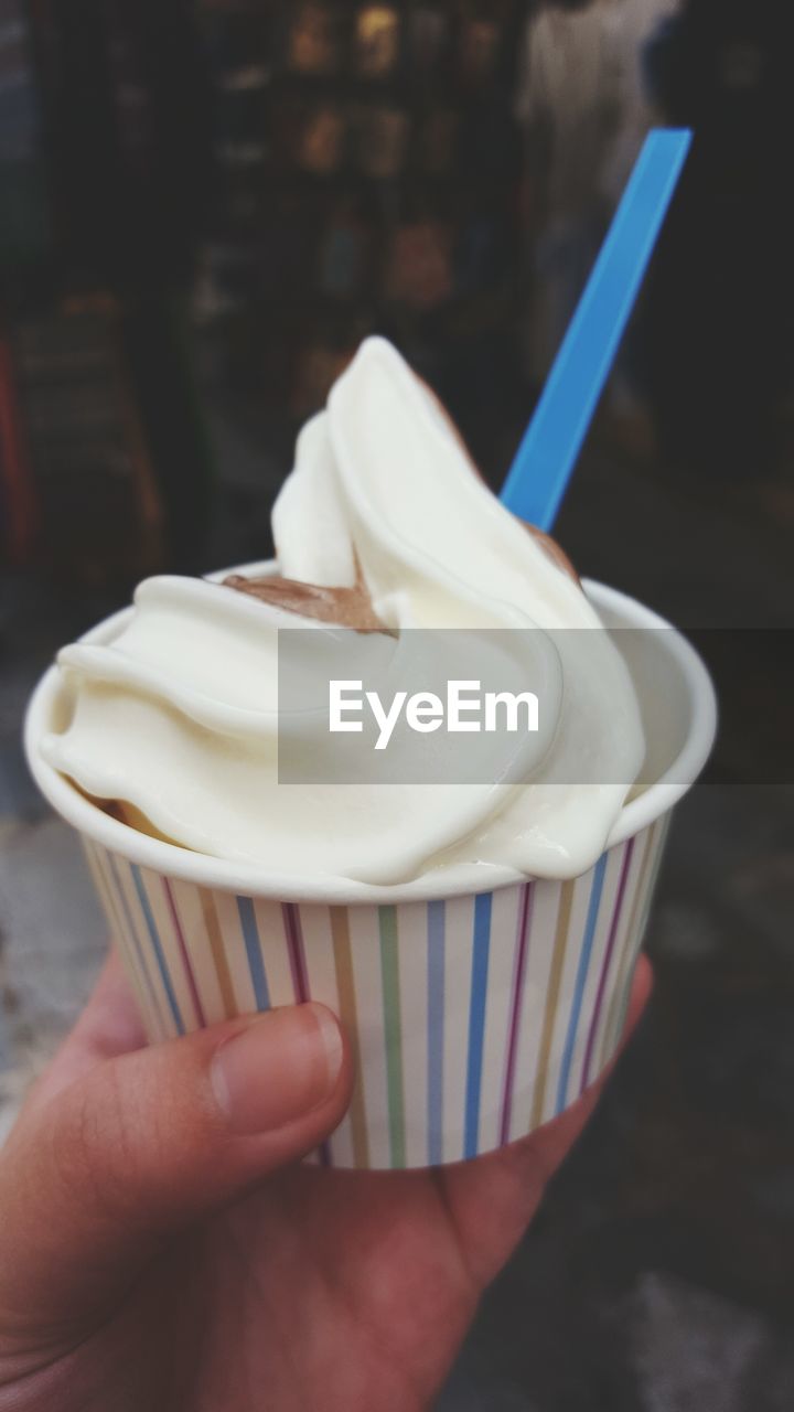 CROPPED IMAGE OF HAND HOLDING ICE CREAM