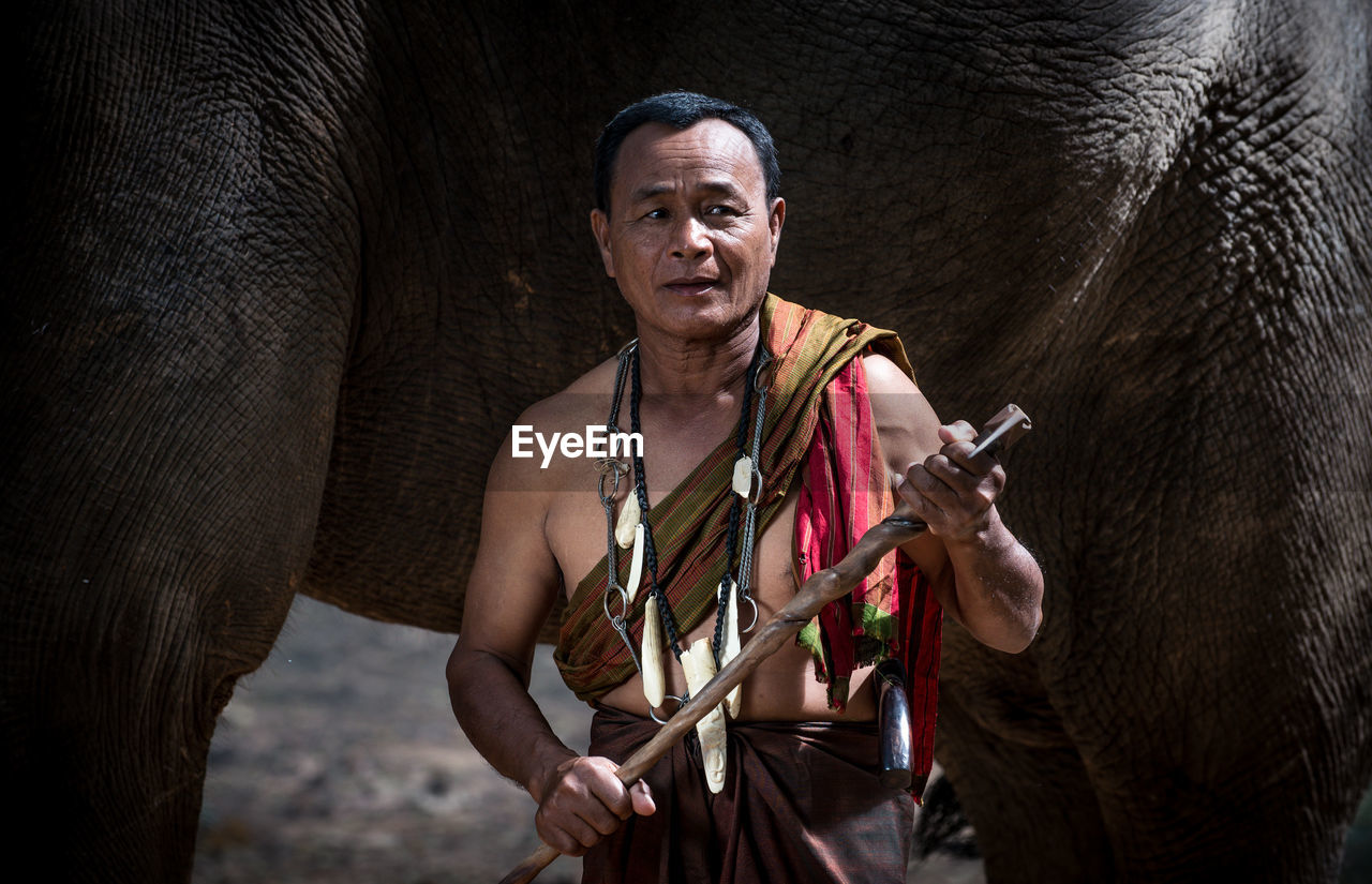 Man standing with elephant in forest