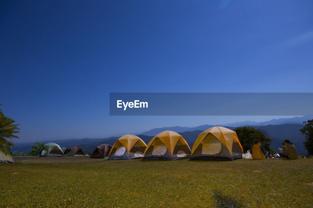 Tent on field against clear blue sky