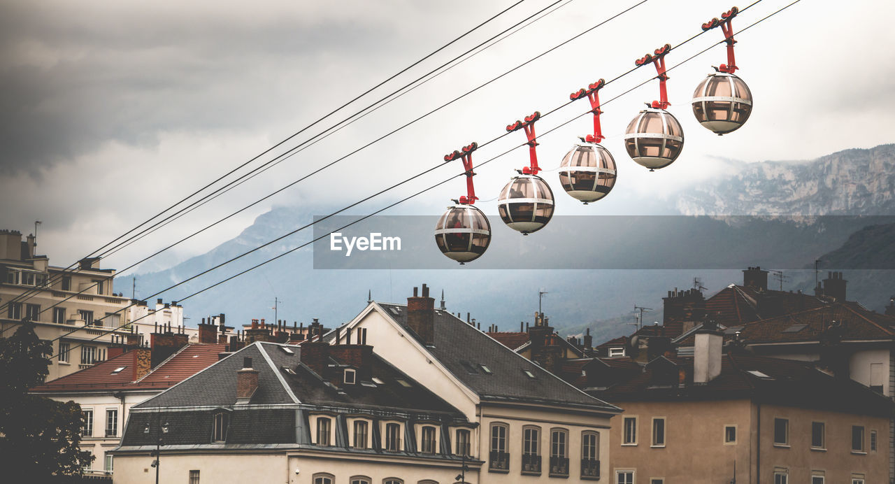 Low angle view of overhead cable cars over buildings in town
