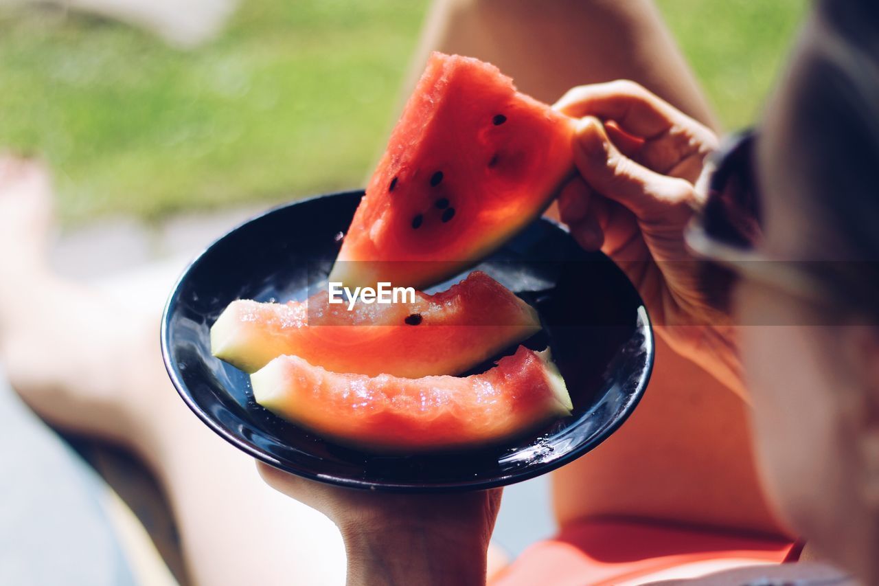 High angle view of woman eating watermelon