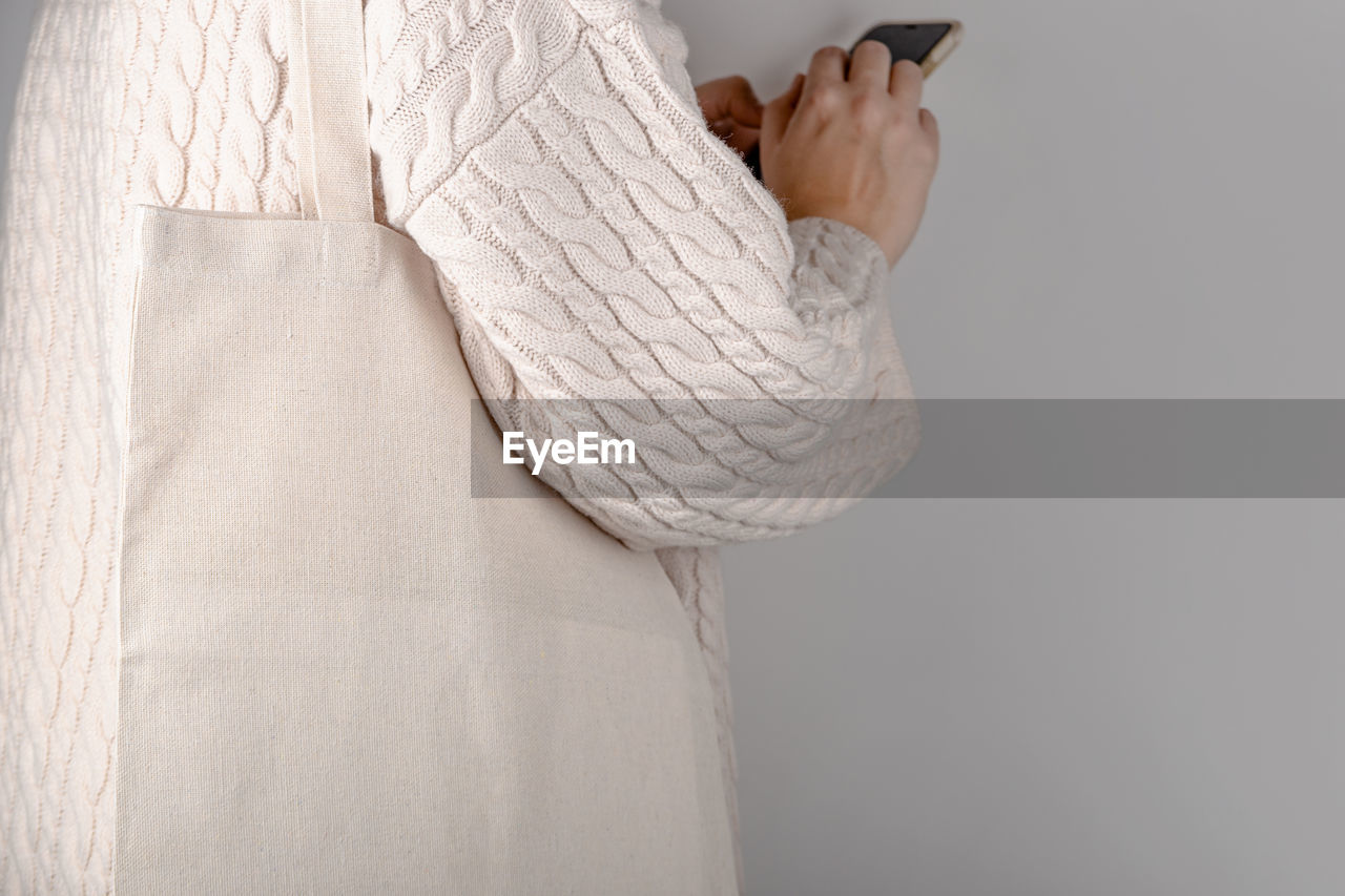 CLOSE-UP OF WOMAN HOLDING WHITE DRESS