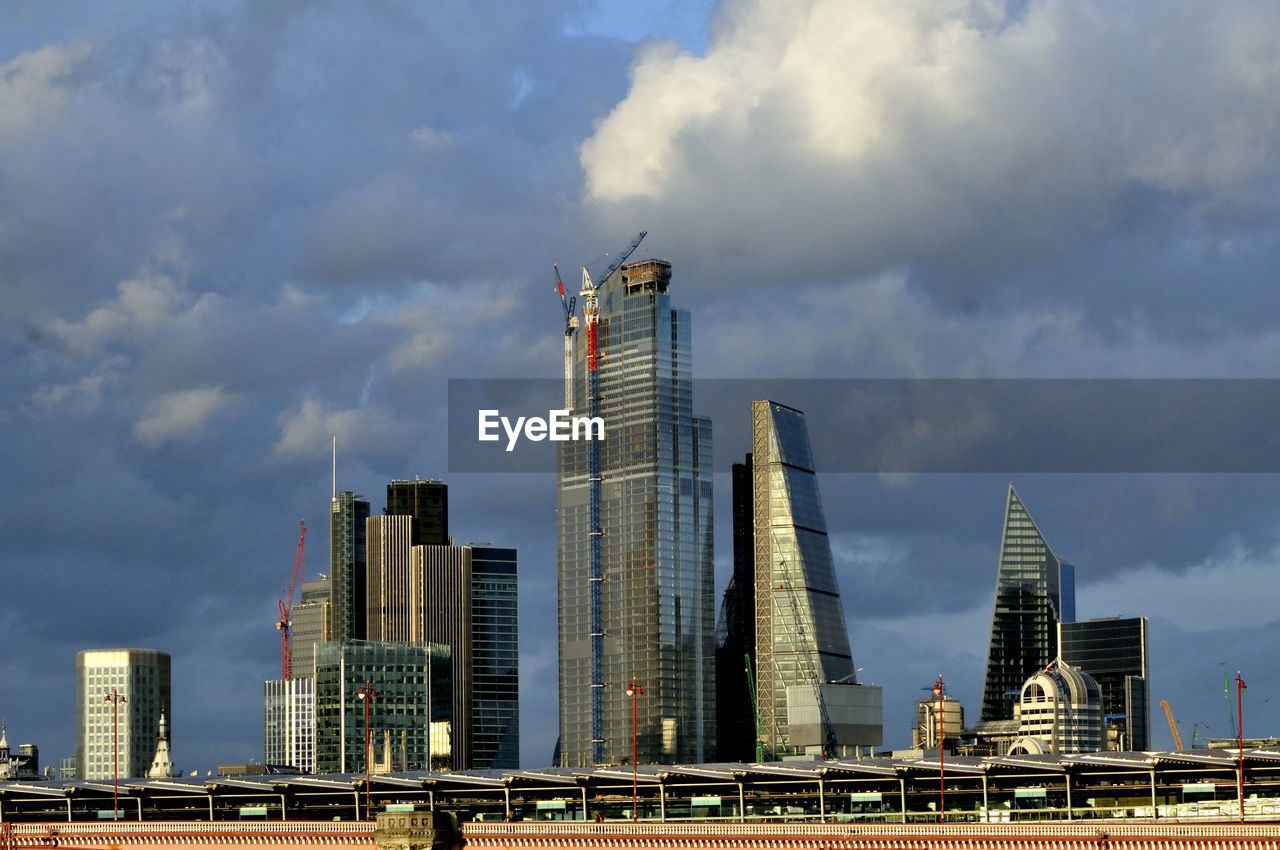 Modern buildings in london against cloudy sky