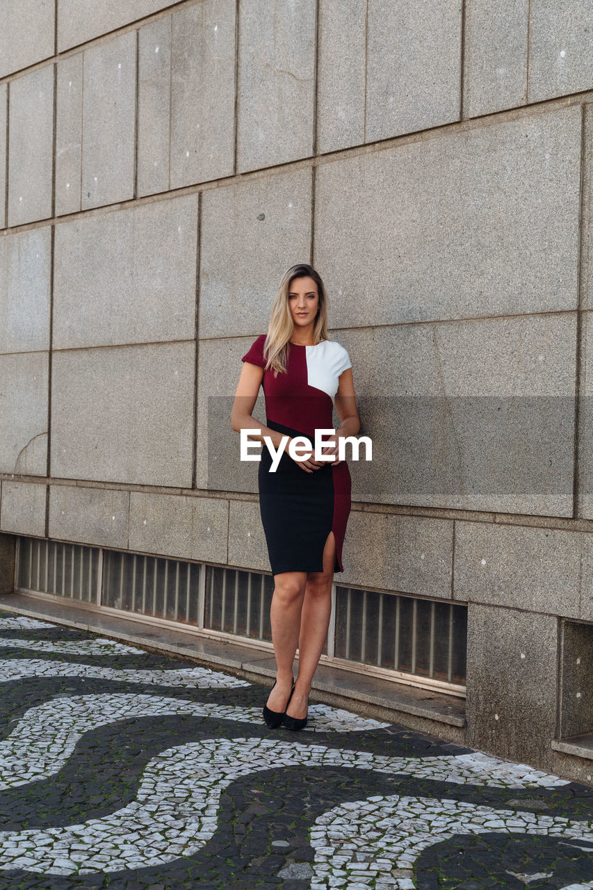 Portrait of woman standing against building