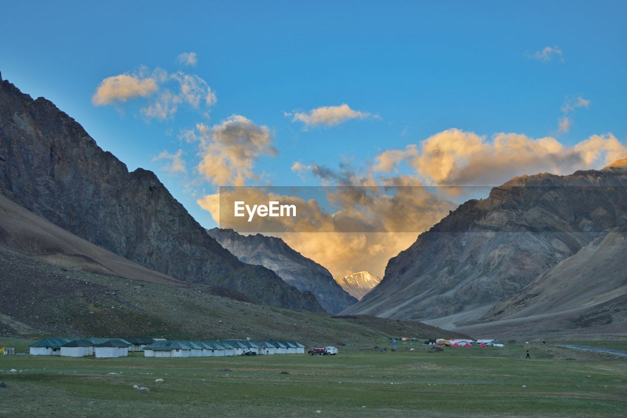 Scenic view of landscape and mountains against cloudy sky