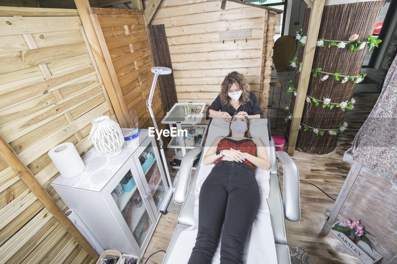 Beautician working with mask and protective screen for the virus covid