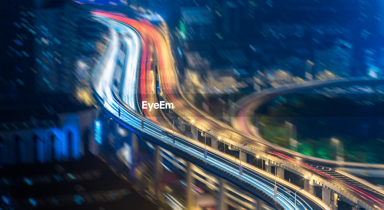 BLURRED MOTION OF LIGHT TRAILS ON ROAD IN CITY