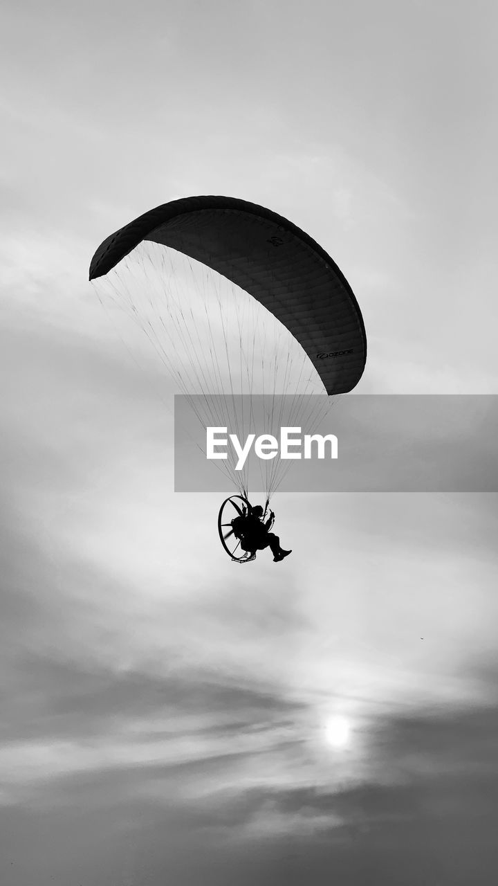 LOW ANGLE VIEW OF PERSON PARAGLIDING AGAINST THE SKY