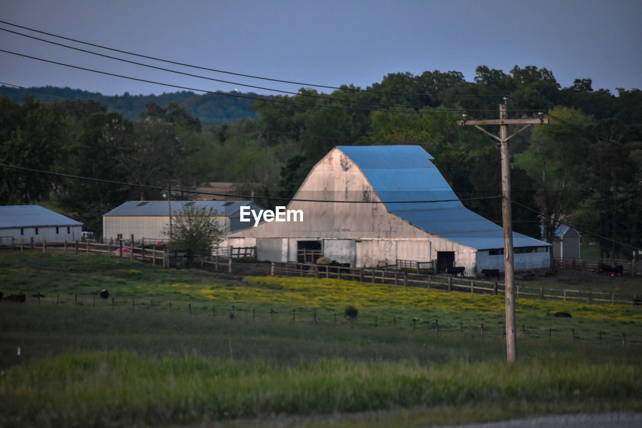 HOUSE ON FIELD AGAINST SKY