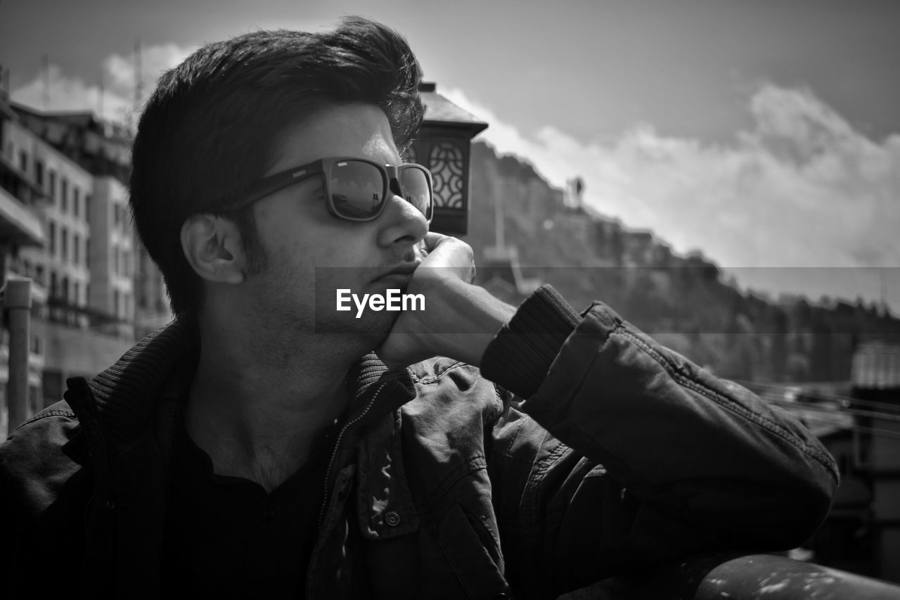 Young man in sunglasses looking away