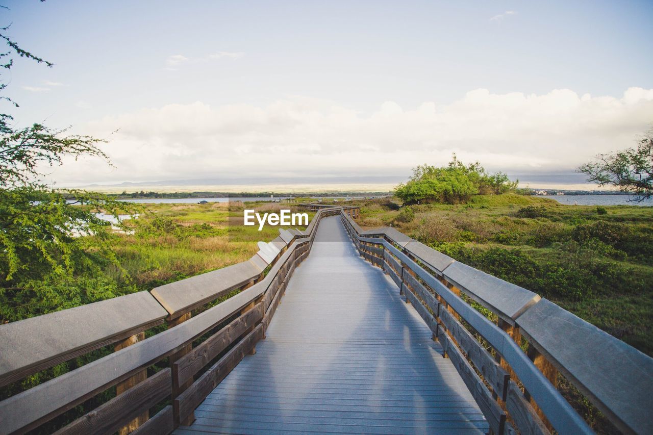 Walkway amidst sea against sky