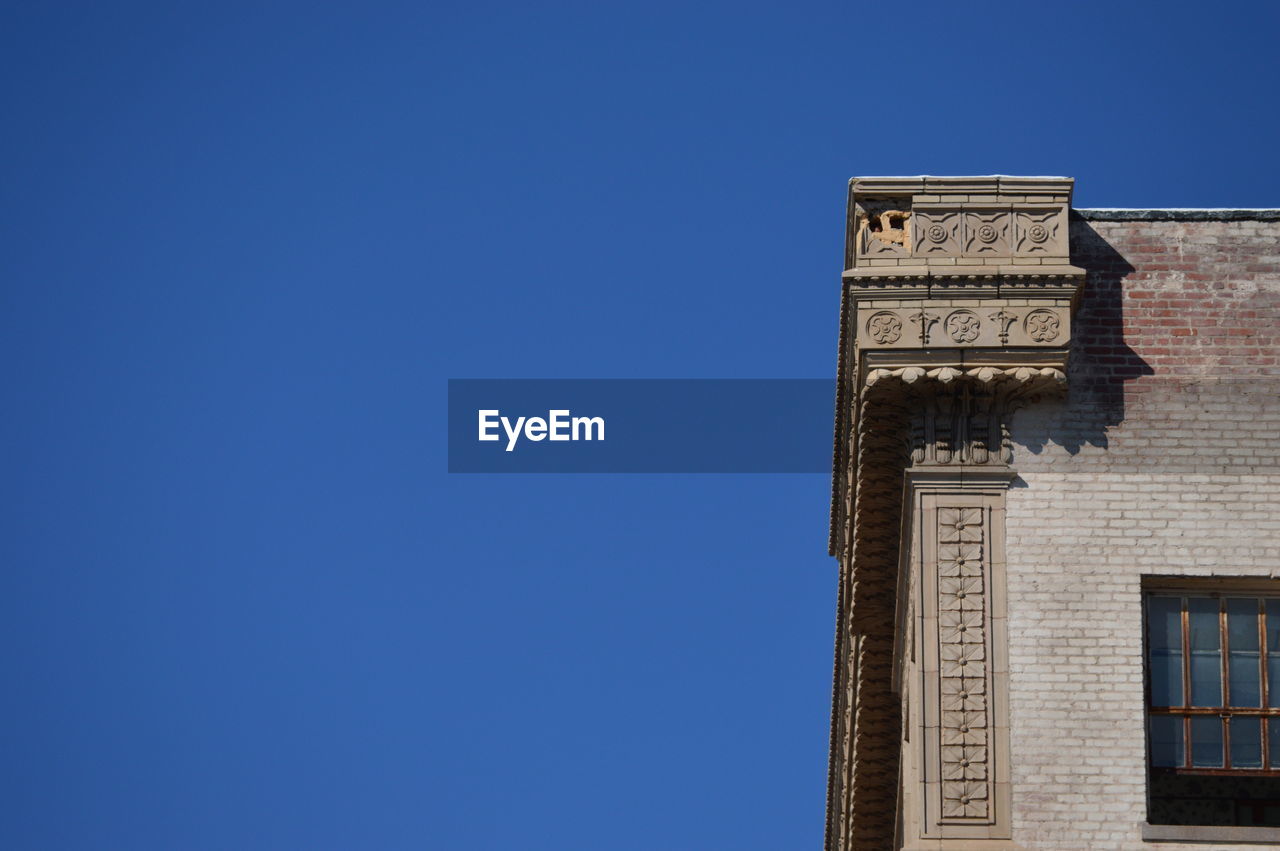 LOW ANGLE VIEW OF BUILDINGS AGAINST CLEAR BLUE SKY