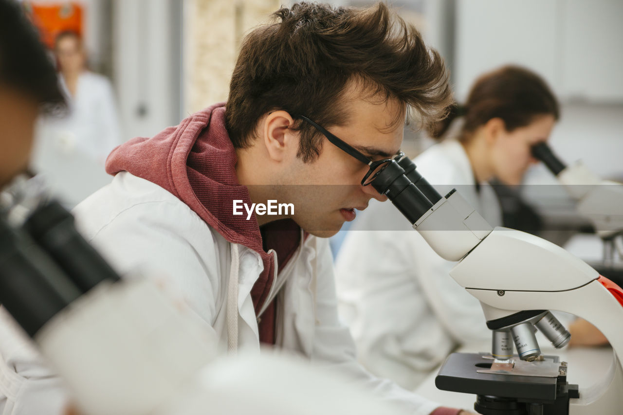 Laboratory technicians using microscopes in lab