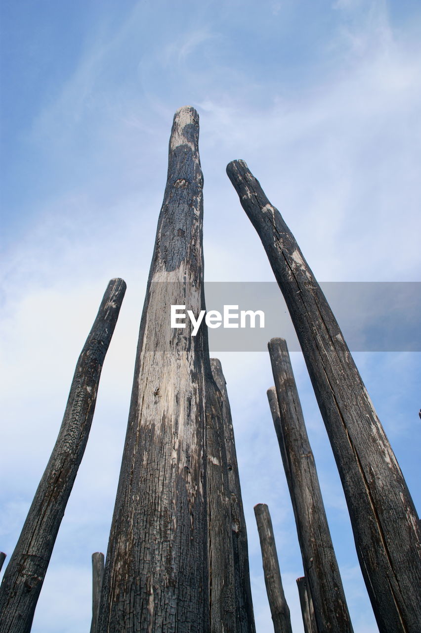 Low angle view of wooden post against sky