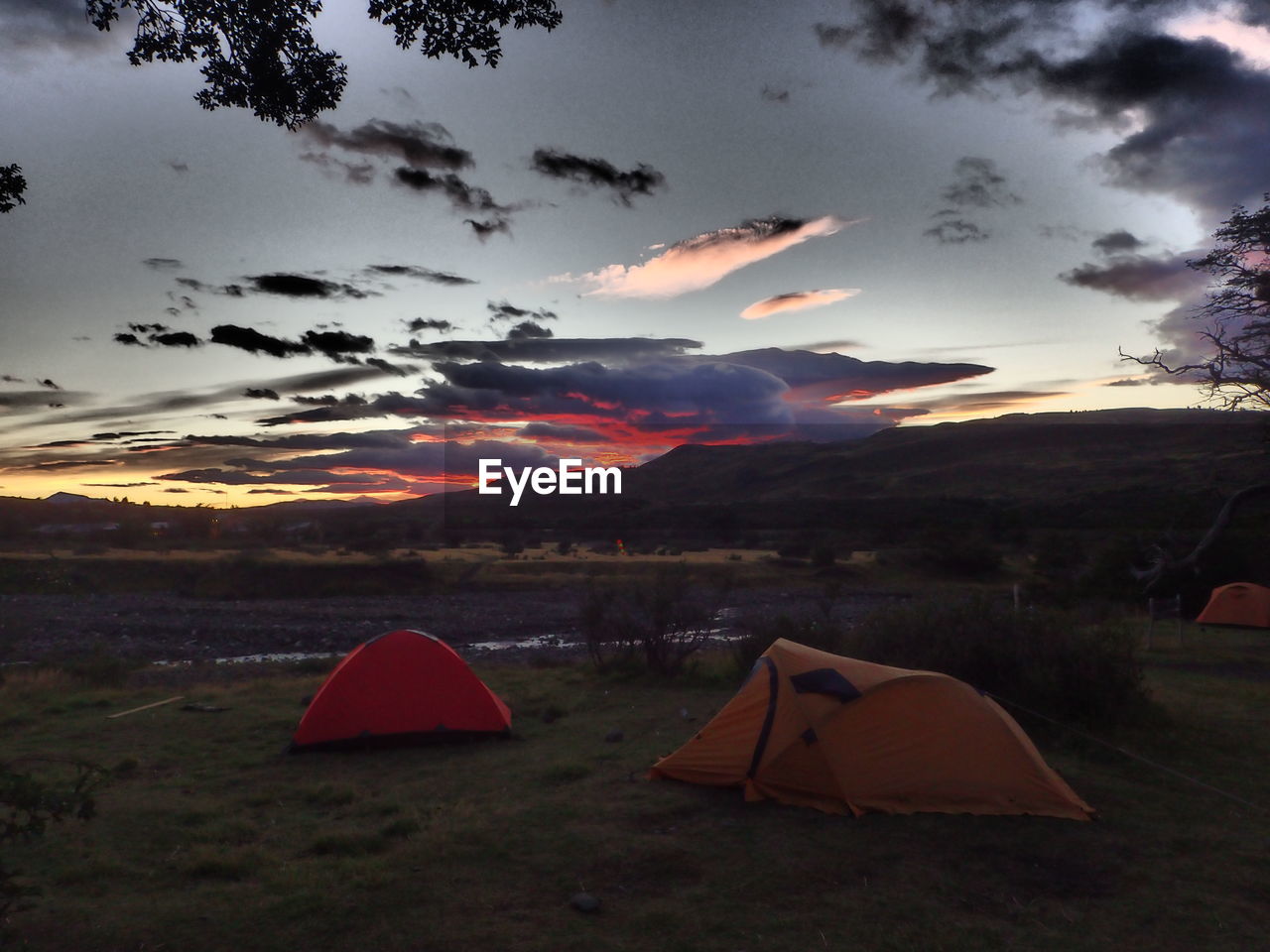 Tents on landscape against scenic sky