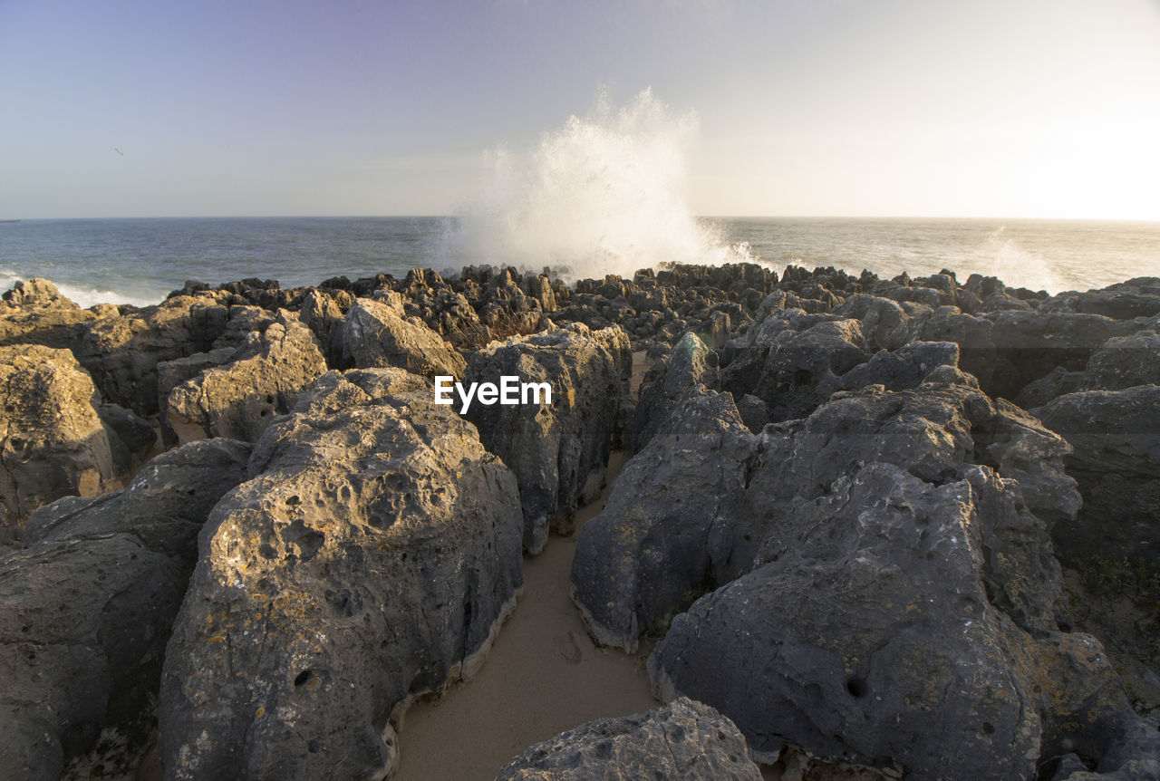 SCENIC VIEW OF ROCKS ON SHORE AGAINST SKY