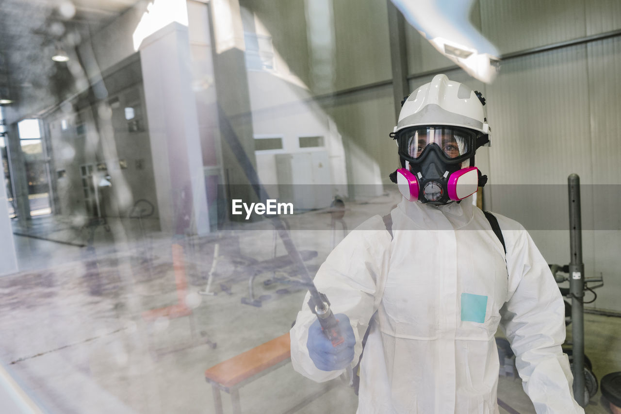 Firefighter disinfecting walls and floors inside a building