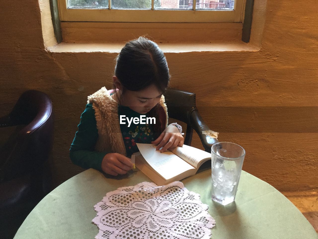 High angle view of girl reading book on table