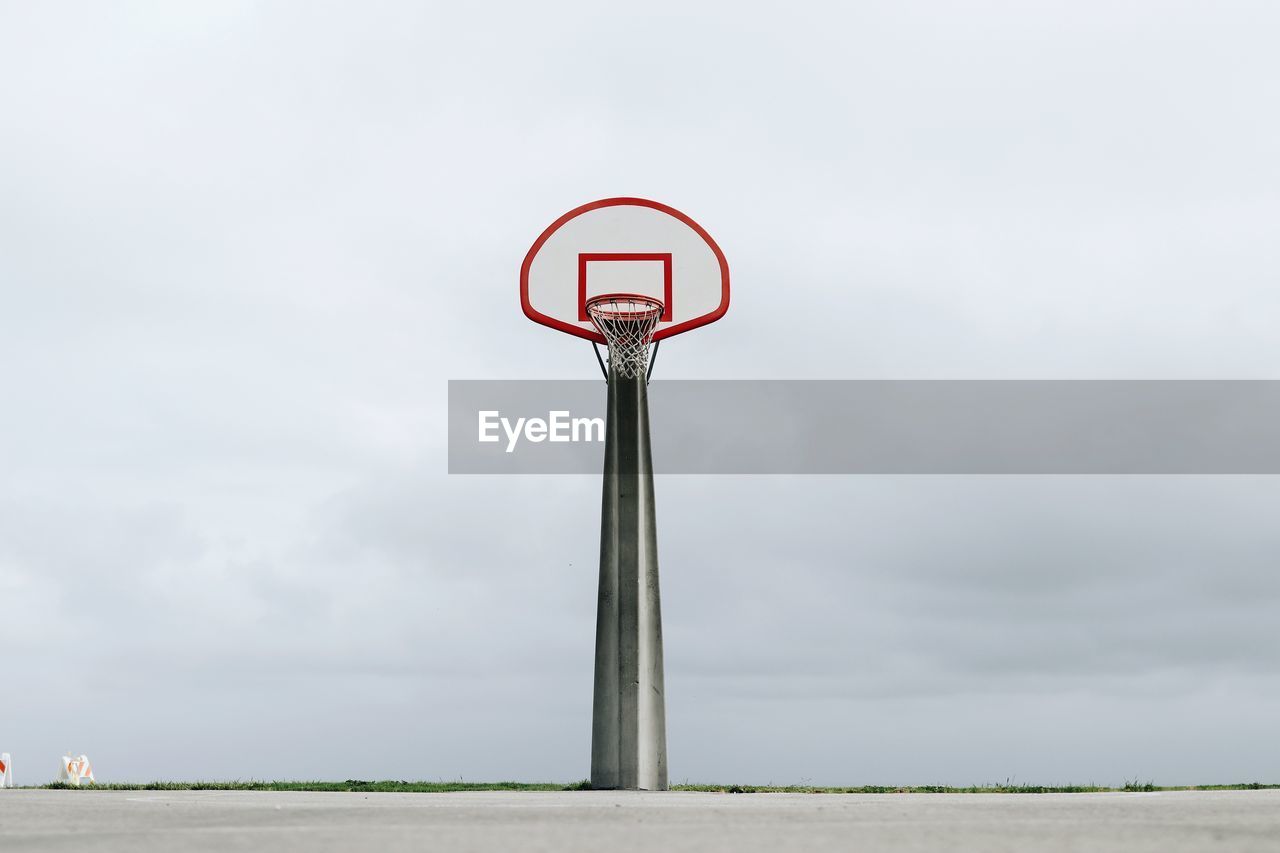 Low angle view of basketball hoop on road against sky