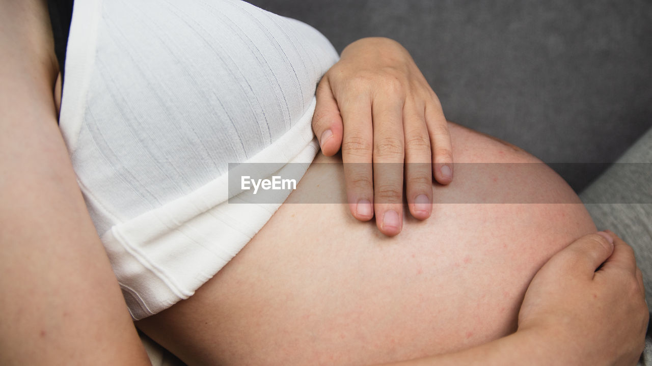 CLOSE-UP OF HANDS TOUCHING WOMAN'S LEGS