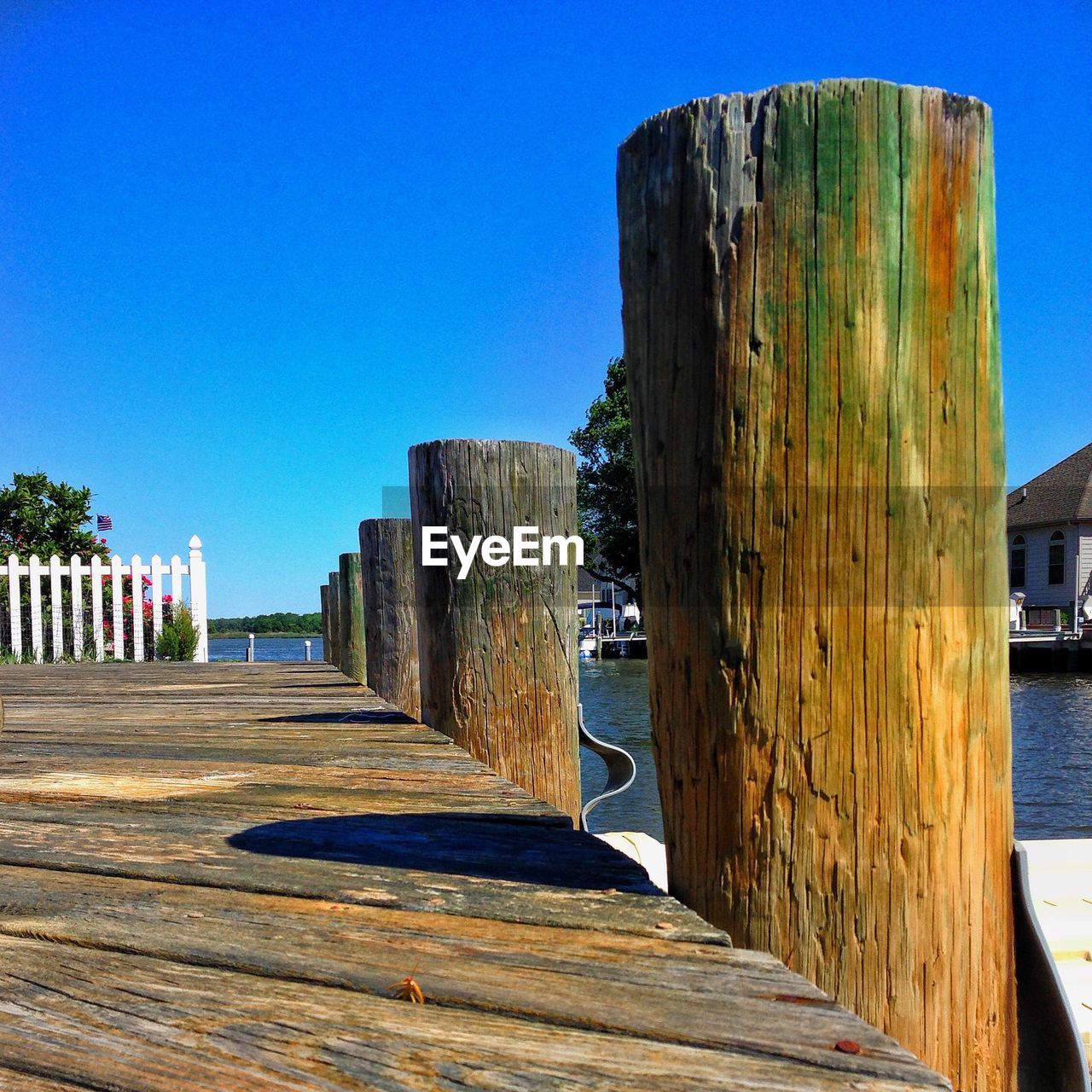 CLOSE-UP OF WOODEN POST AGAINST CLEAR BLUE SKY