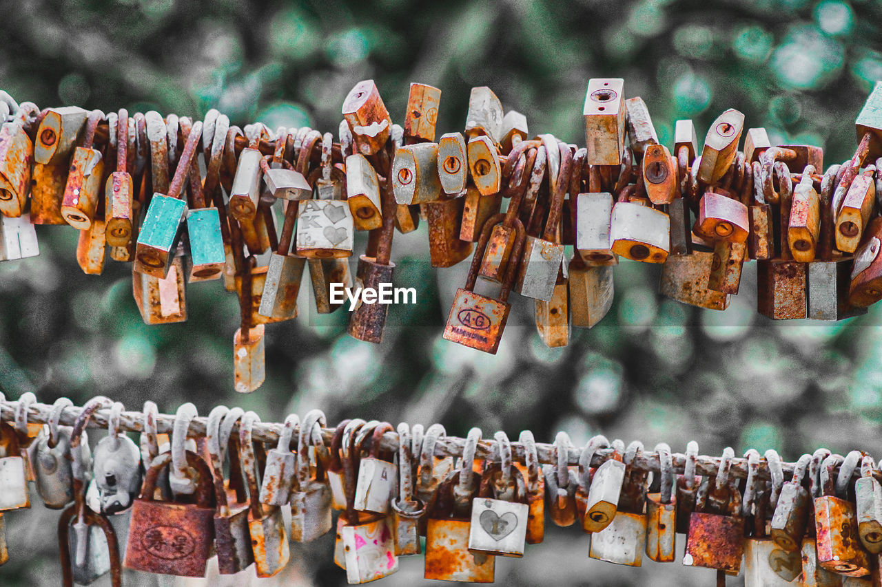 CLOSE-UP OF LOVE PADLOCKS HANGING IN METAL