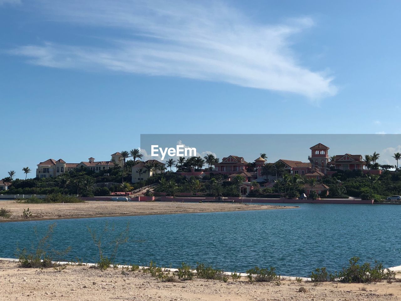 Scenic view of sea by buildings against sky