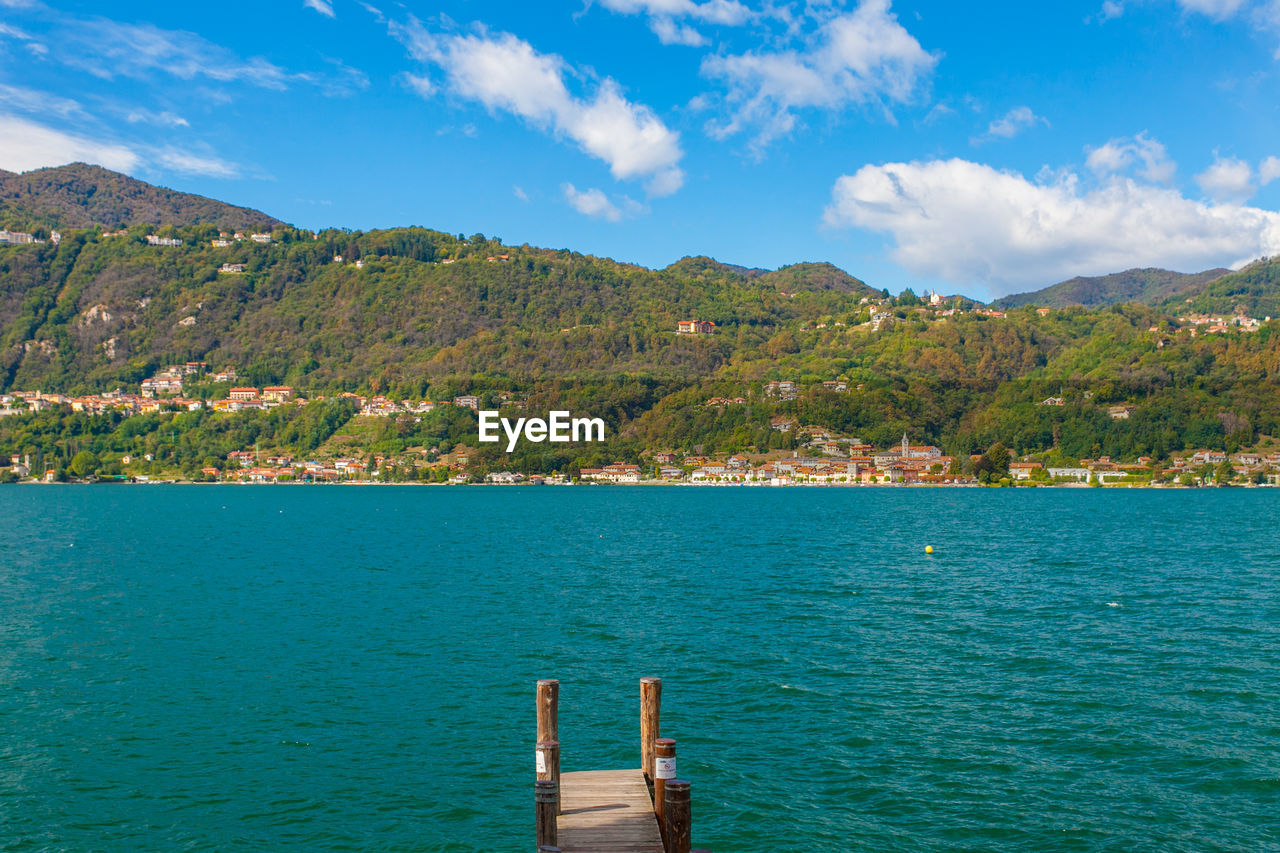 Scenic view of sea by mountains against sky