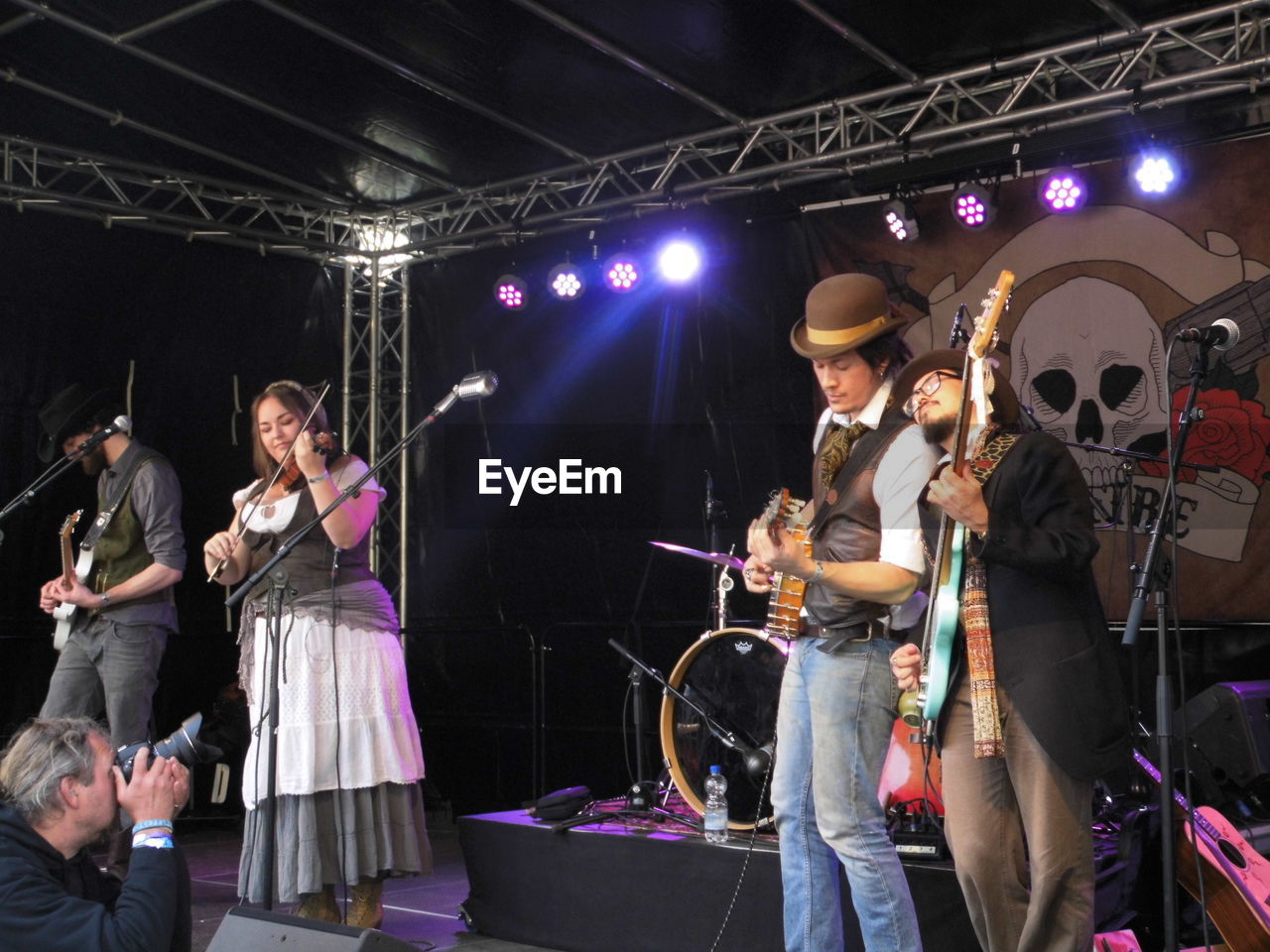 GROUP OF PEOPLE PLAYING GUITAR AT CONCERT