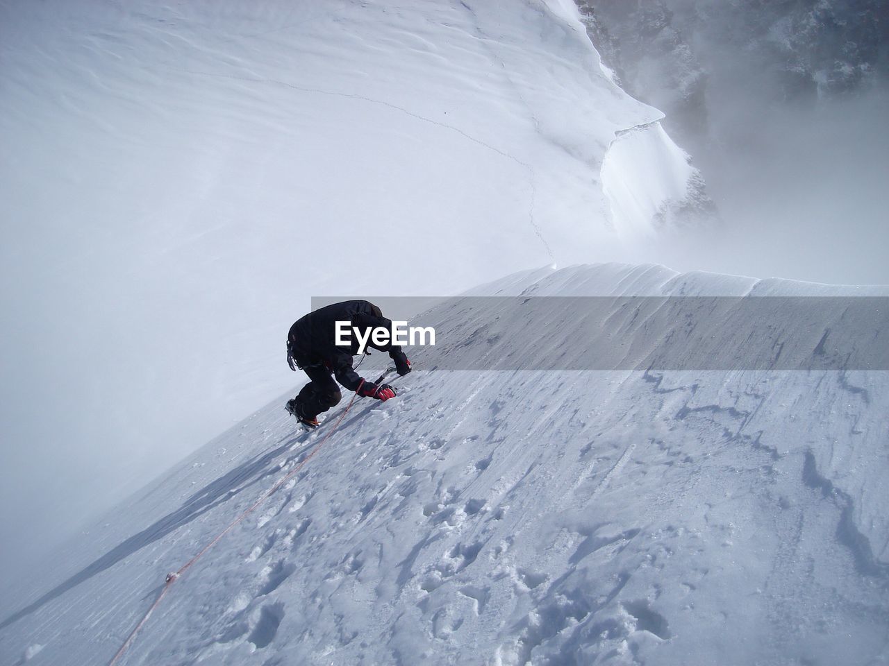 Man climbing snow covered mountain