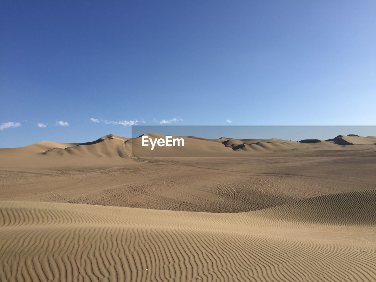 Scenic view of desert against blue sky