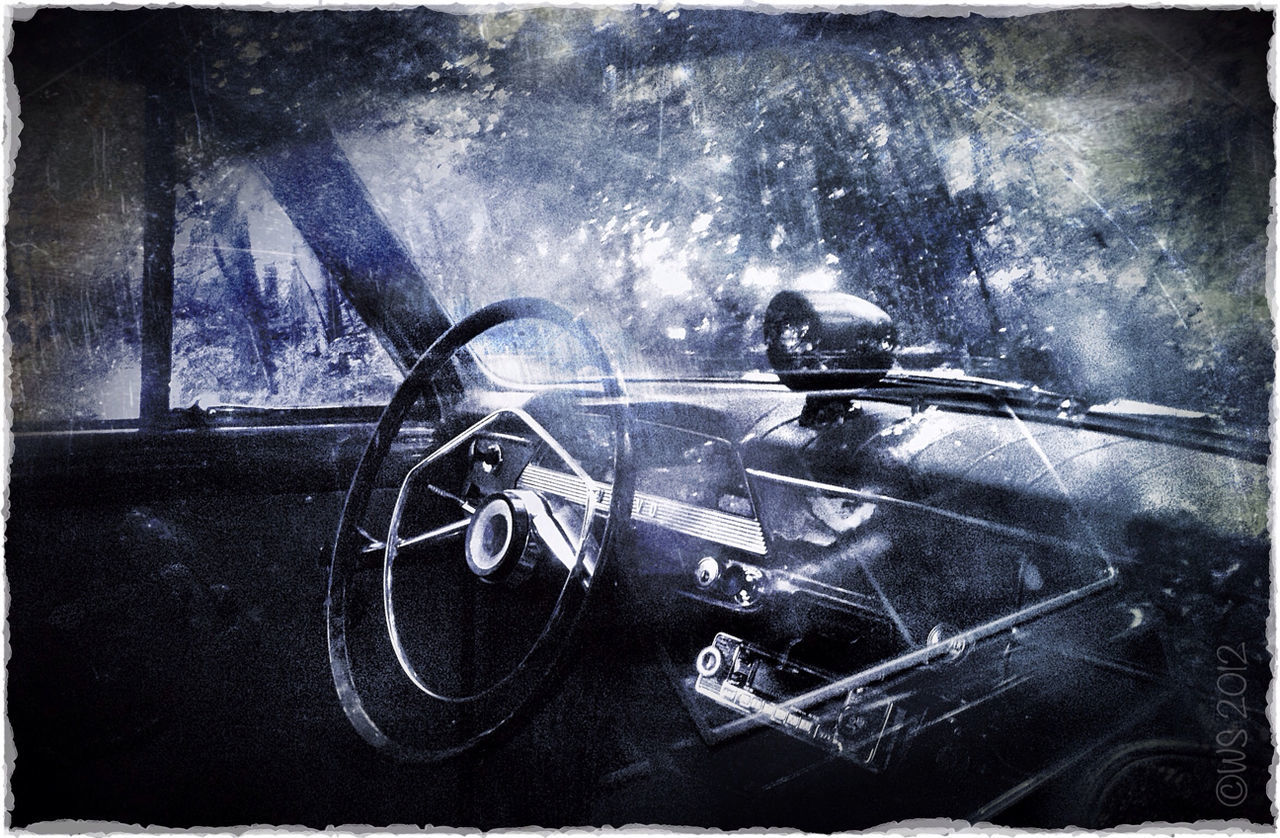 Steering wheel of car seen through glass window