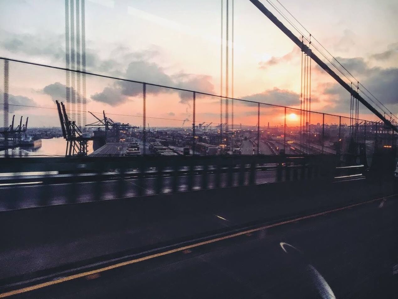 VEHICLES ON ROAD AT SUNSET