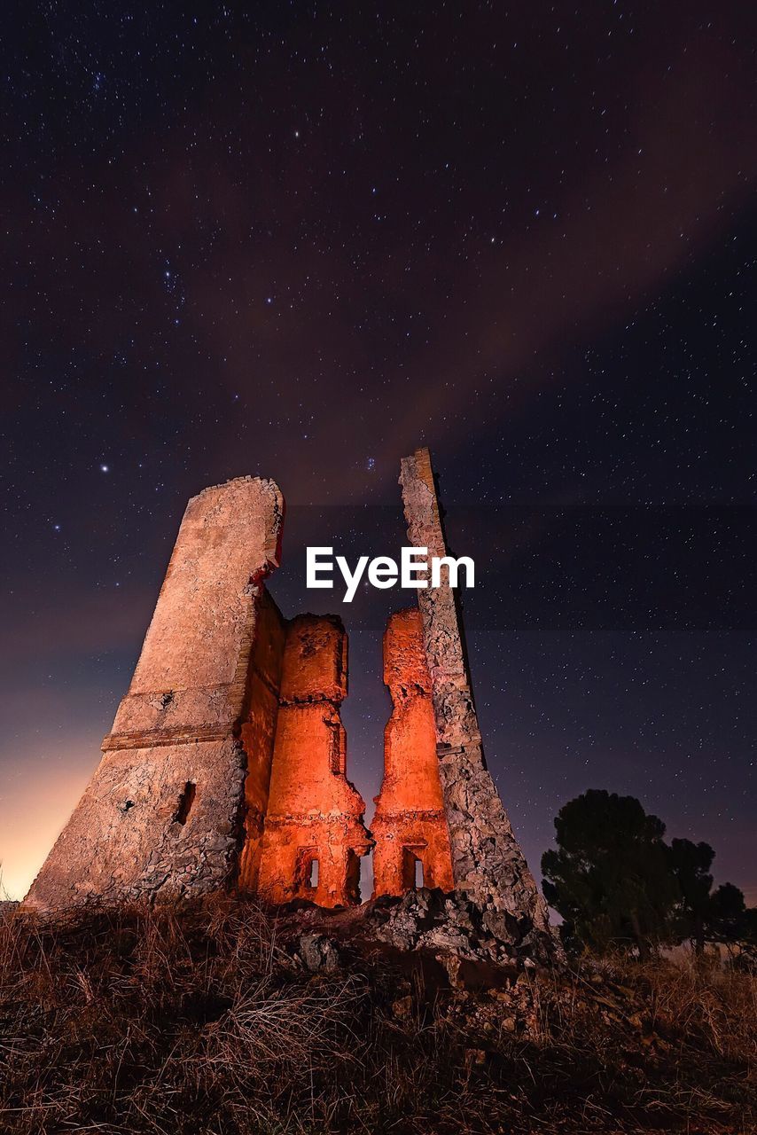 LOW ANGLE VIEW OF ILLUMINATED MOUNTAIN AGAINST SKY