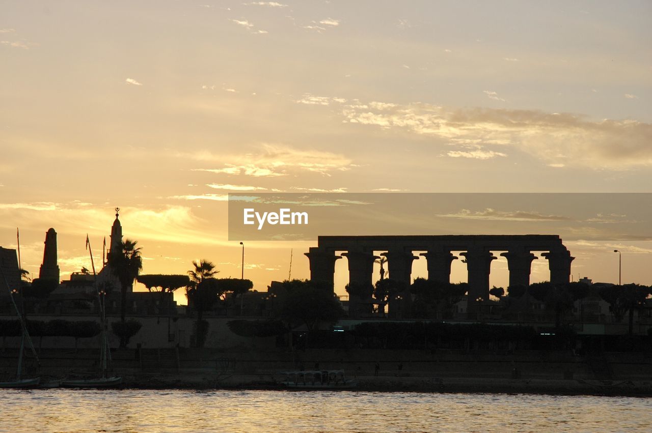 SILHOUETTE OF CITY AT RIVERBANK DURING SUNSET