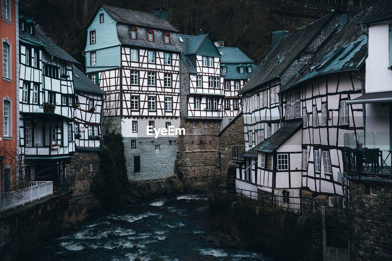 Moody winter scene from monschau germany with historic half timbered buildings lining the river. 